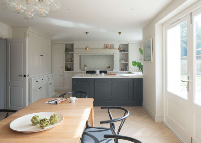 Kitchen with navy island, white cabinetry, and dining table by French doors.